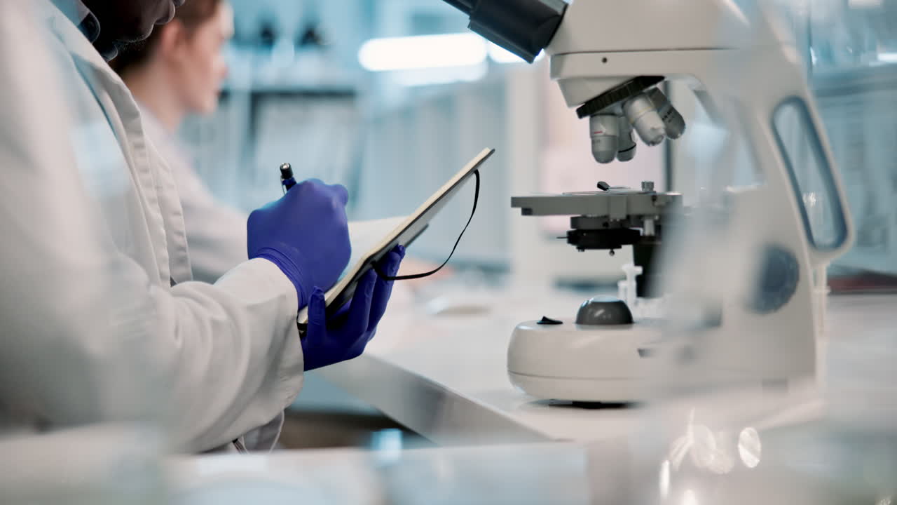 Scientists working in a laboratory with a microscope