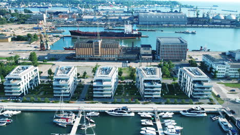 scenic marina with boats and city skyline in gdynia, poland - aerial shot