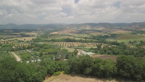 Aerial-view-of-Saturnia-Hot-Springs,-in-Tuscany-countryside-,-drone-revealing-scenic-hills-landscape