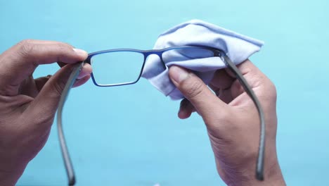 cleaning eyeglass with a cloth close up