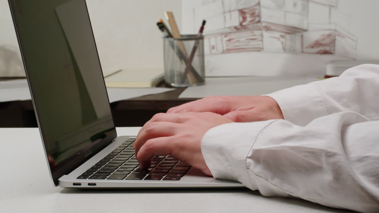Person Typing on Laptop in an Office Environment