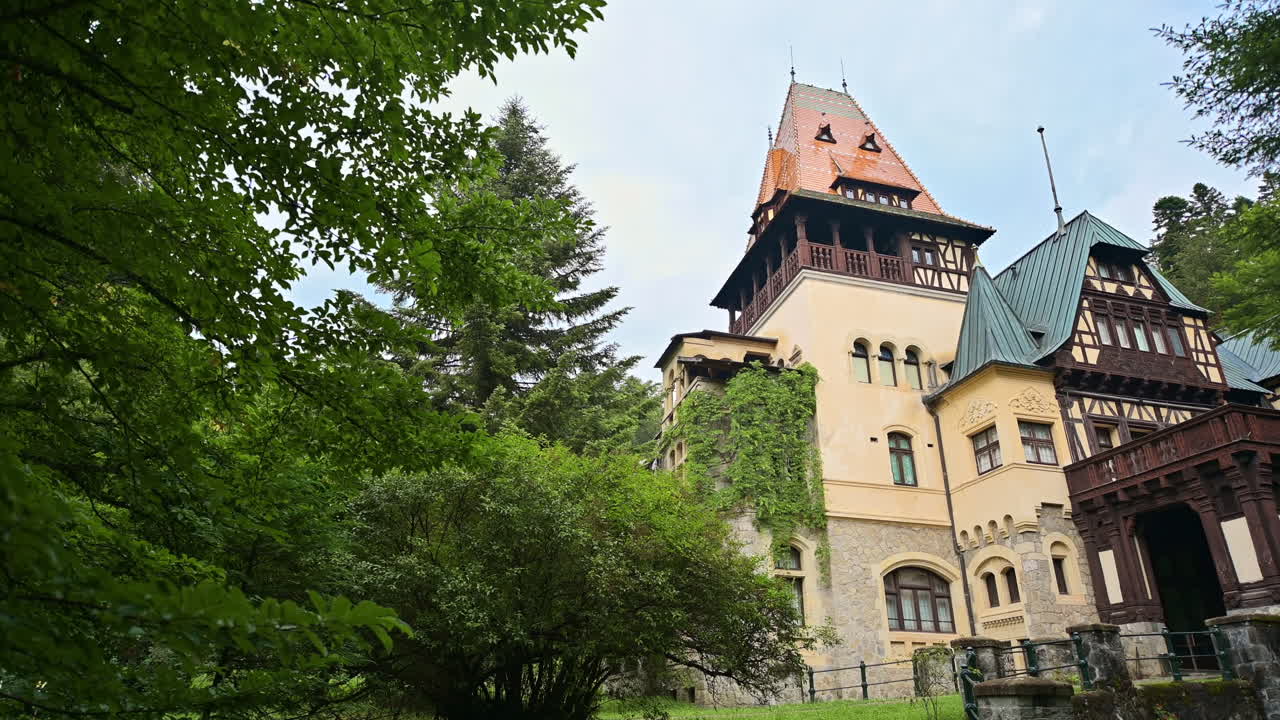 Vista del Castello di Pelișor in Romania. Castello con giardini di fronte, situato sui Carpazi e circondato da una lussureggiante foresta