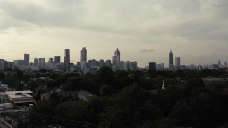 the marta metro train in atlanta georgia passes by closely in the foreground of a gorgeous aerial shot of downtown atlanta skyline