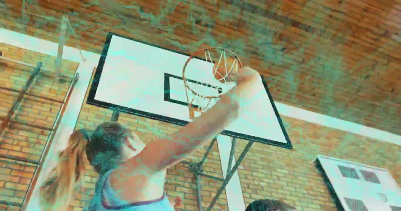 Giocatrice di basket adolescente che schiaccia la palla attraverso il canestro della palestra, mostrando statistiche sportive animate.