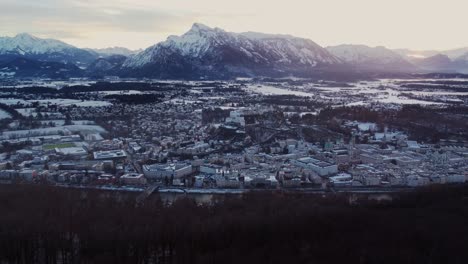 Toma-Aérea-De-4k-Del-Paisaje-Urbano-De-Salzburgo-Al-Atardecer,-Castillo-Y-Alpes,-Austria