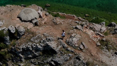 Person-exploring-the-decrepit-historic-cold-war-bunkers-at-Lin-Village,-Albania