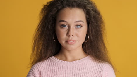 caucasian curly haired woman looking at the camera.