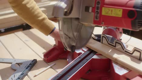 the worker saws the marked piece of wood