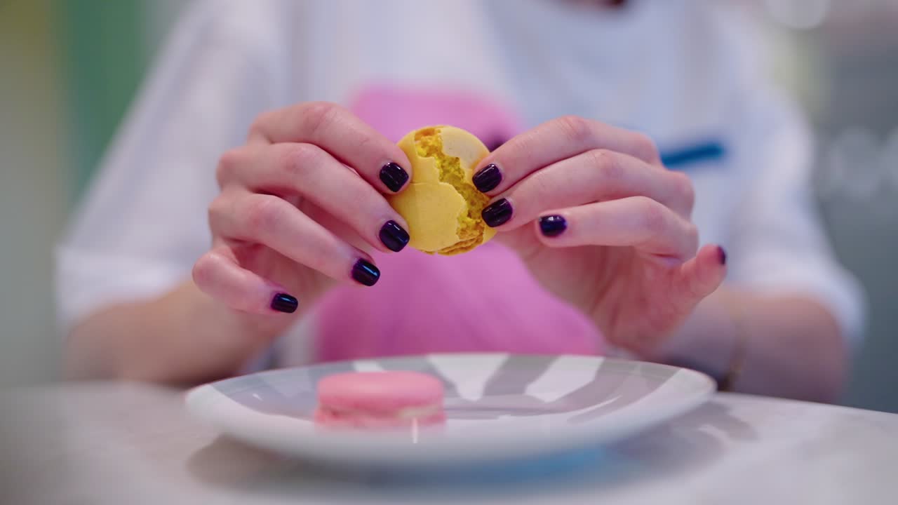 una dama rompiendo un macaron dulce