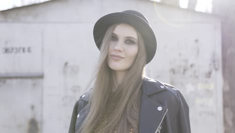 mujer elegante con sombrero negro y chaqueta de cuero