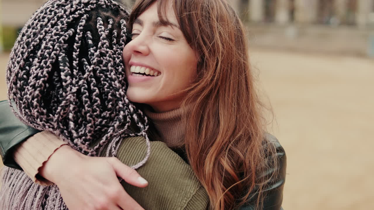 Due donne felici che si abbracciano all'aperto con sorrisi gioiosi