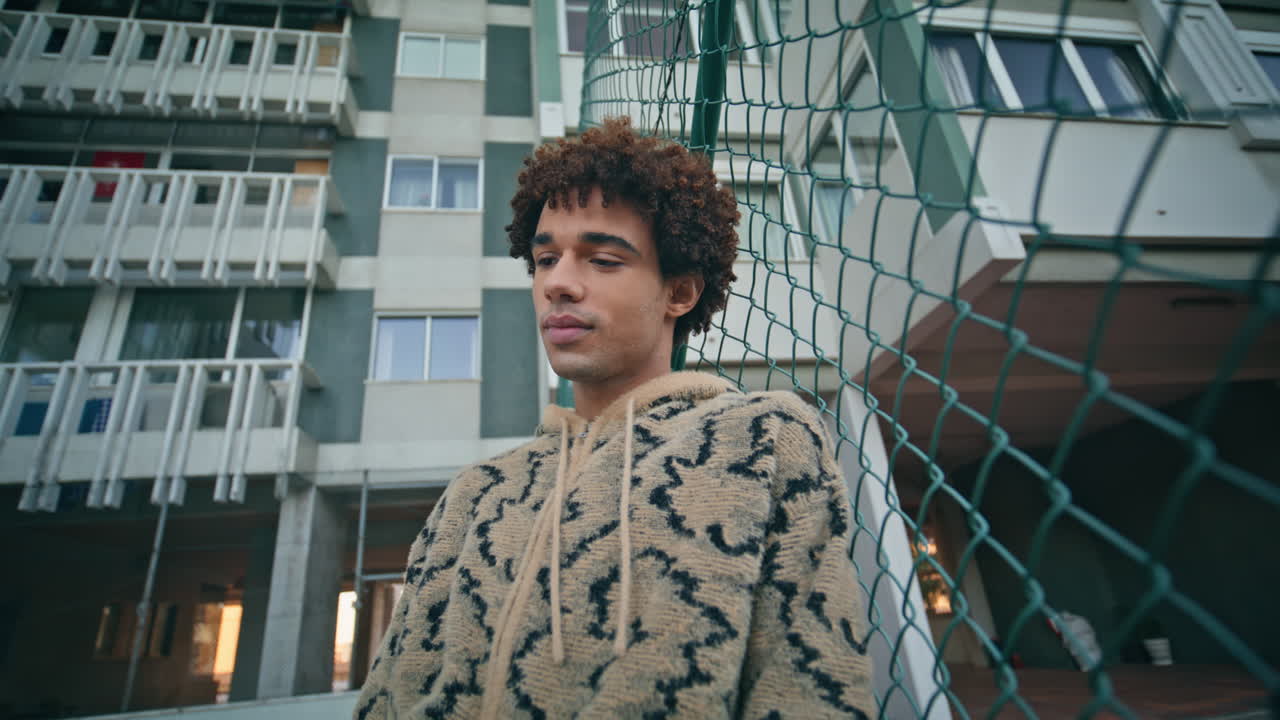 스타일리시 러는 도시 거리를 서서 도시 울타리에 기대고 클로즈업 아웃합니다.