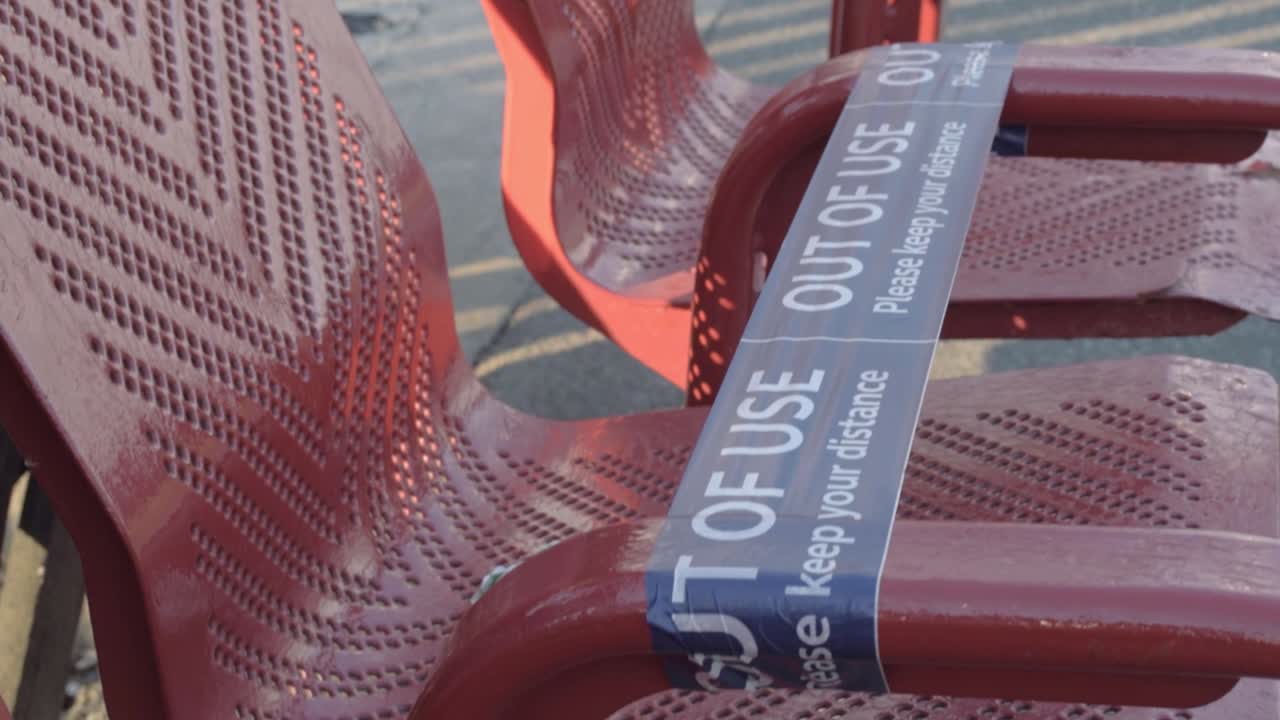 Seats in a train station with social distancing tape