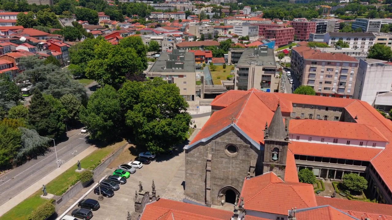 Luftfoto - Igreja de São Francisco stenkirke med klokketårn og røde tage i Guimaraes