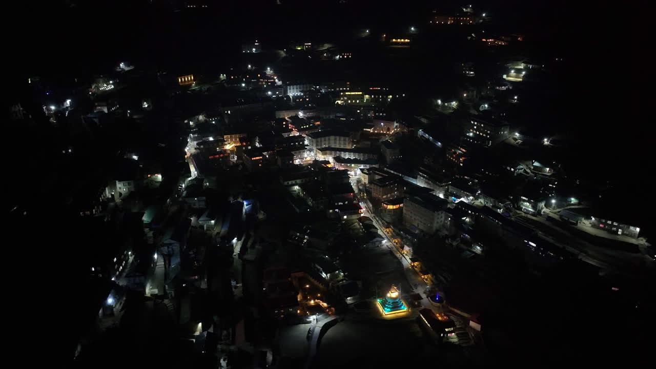 Nighttime aerial of Namche Bazaar, Everest region Nepal, showing houses lit by solar power in the Himalayan landscape night time lifestyle of lively village