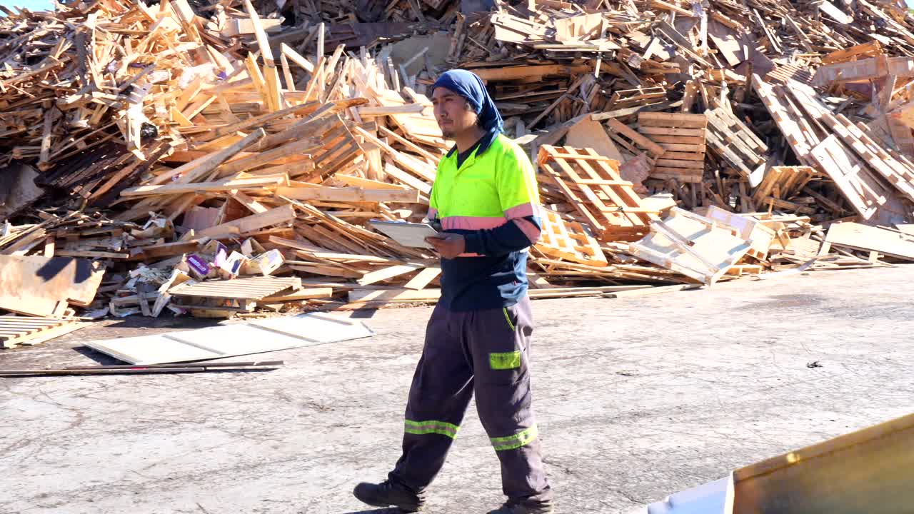 Uomo con blocco appunti in una segheria