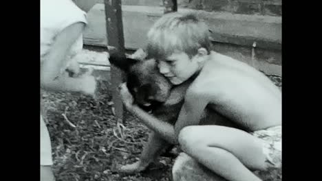 boy hugging dog in touching black and white video. circa ussr 1970: a heartwarming black and white video captures a boy tenderly embracing a dog.