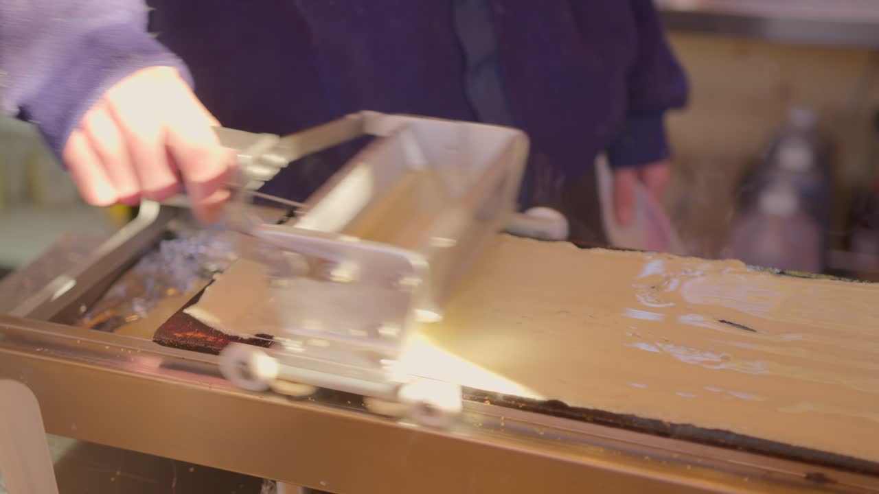 조리되지 않은 팬케이크 반죽을 핫플레이트에 퍼뜨리는 사람의 클로즈업