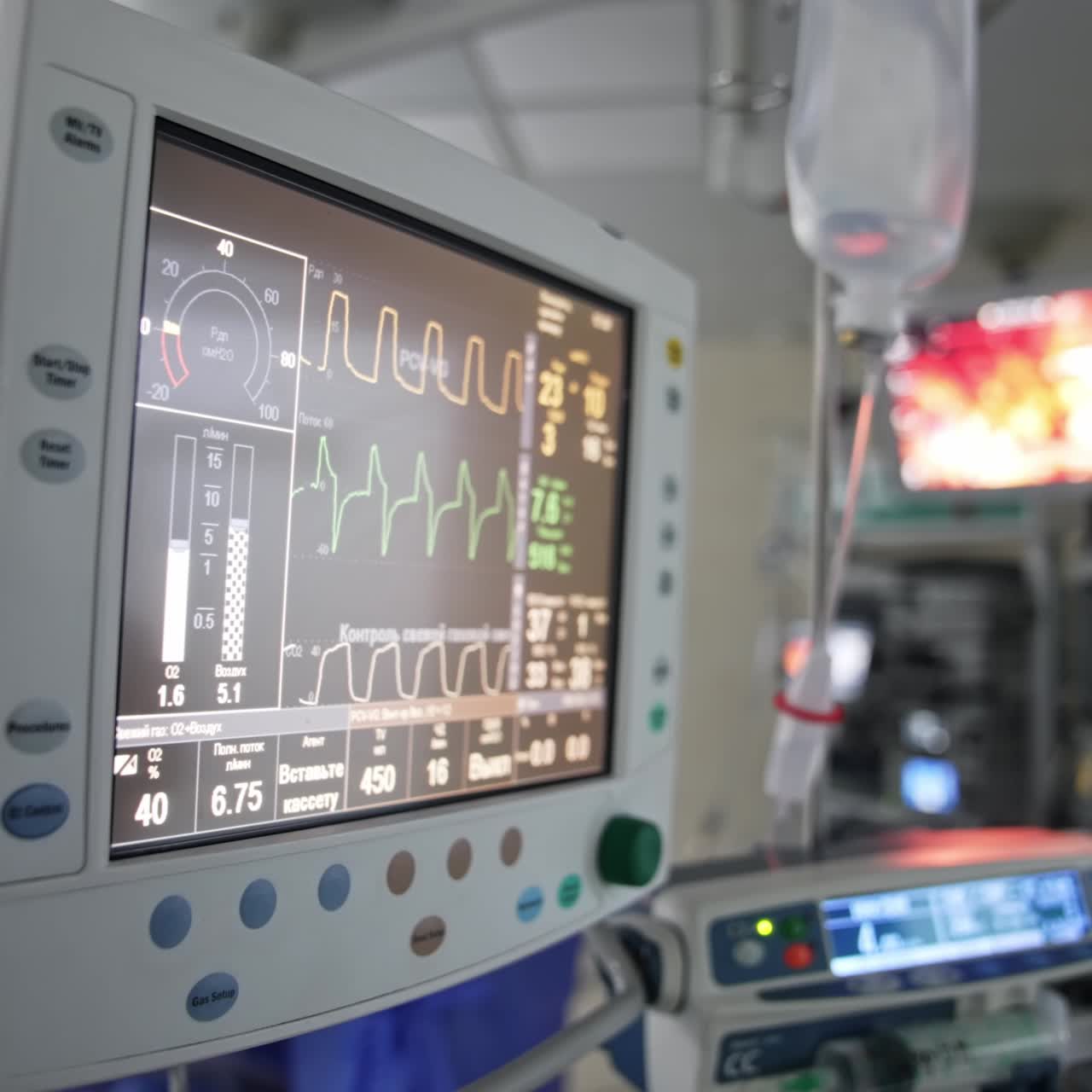 Curved lines running on the monitor of artificial lung machine. Equipment helping to control patient's condition at operation. Blurred backdrop