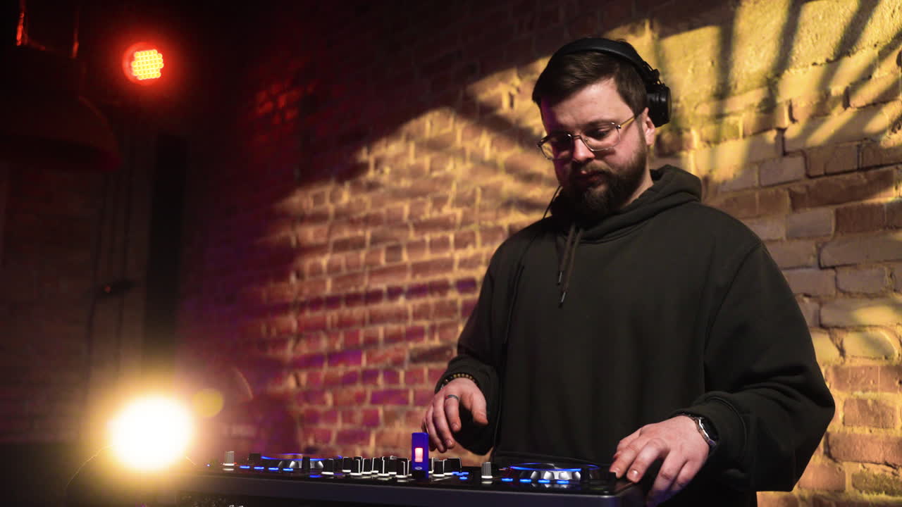 hombre con gorra negra pinchando en la discoteca.