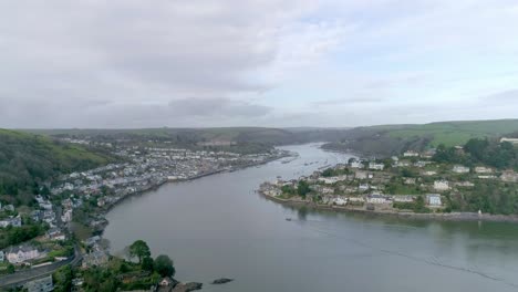 antena de seguimiento hacia adelante sobre árboles espesos de invierno hacia la entrada de la ciudad de tradición naval de dartmouth, devon