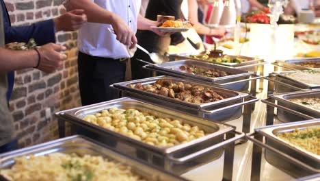 personas de catering de grupo comida buffet en interiores en restaurante de lujo con carne frutas y verduras de colores.