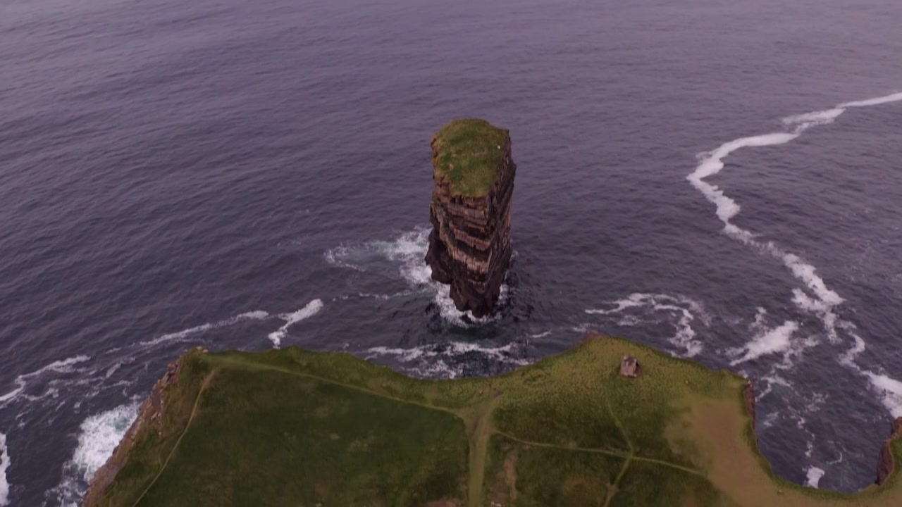 Inquadratura con drone in picchiata sul faraglione Dun Briste vicino alle scogliere di Downpatrick Head, un'imponente colonna stratificata nell'oceano