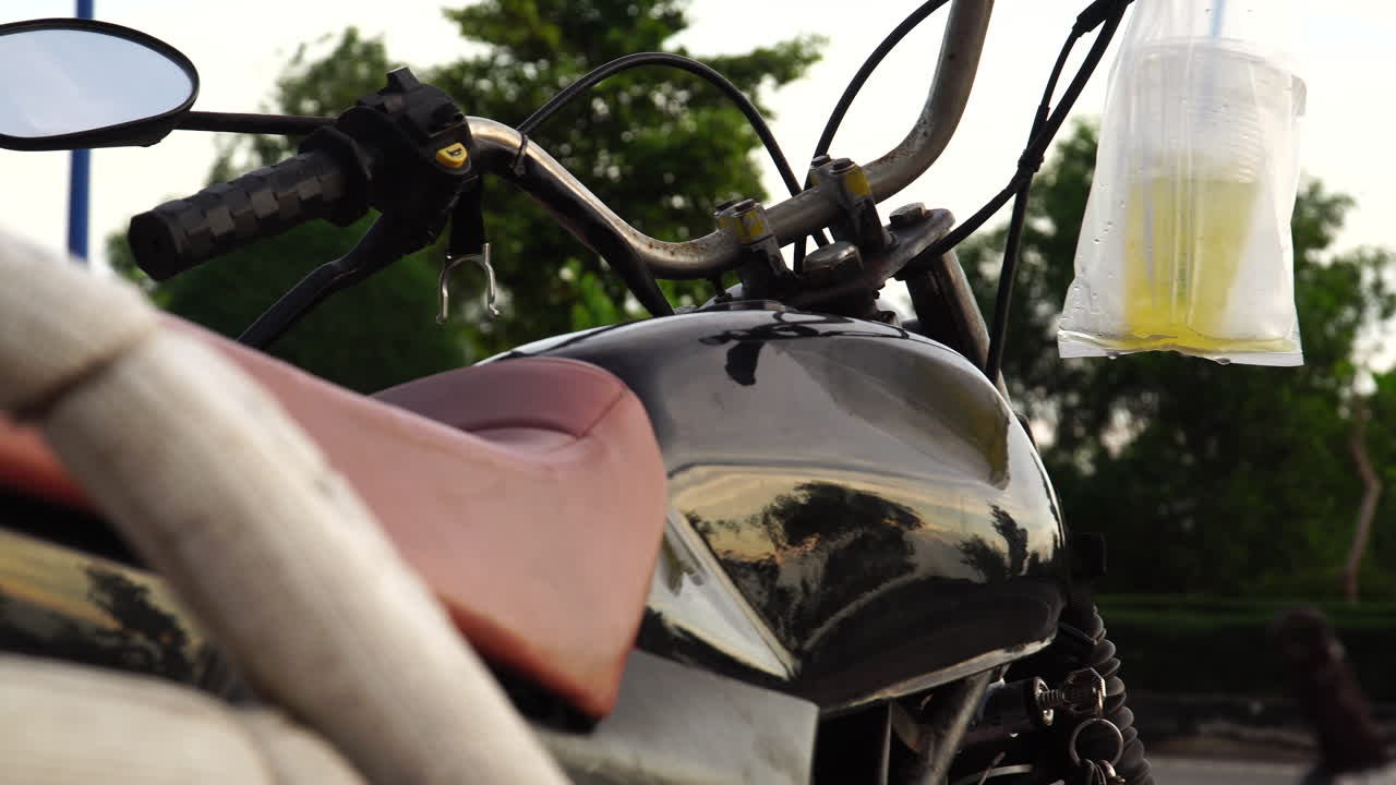 tiro deslizante derecho de una motocicleta estacionada con un vaso de bebida en el manillar