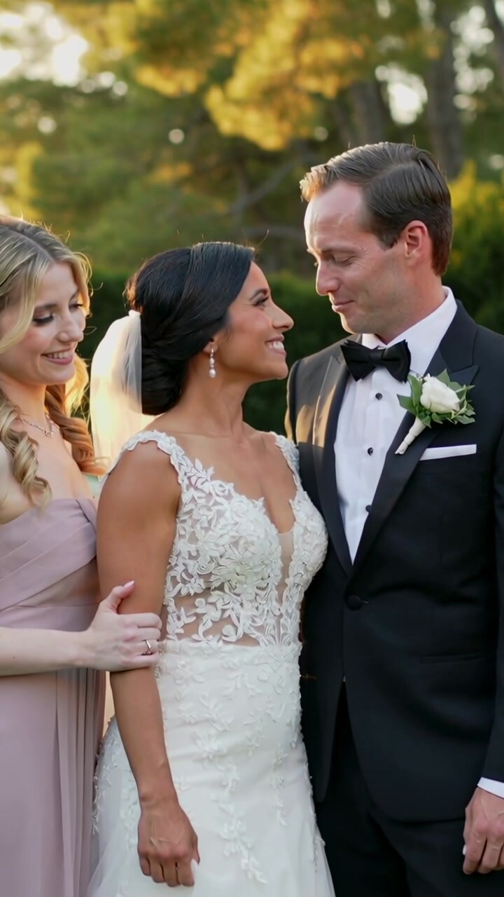Vertical video: Leaning groom moving after warm gaze in park, bridesmaid holding arm, lace gown