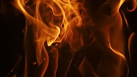 slow motion footage of wood burning in a fireplace with the fire licking the wood, background with copy space