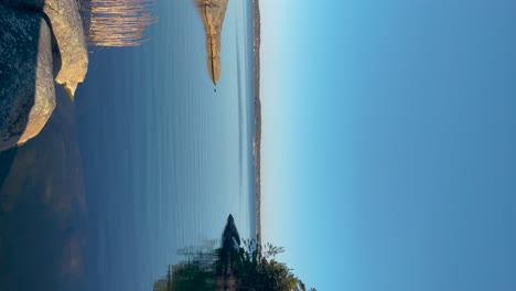 Calm-waters-of-the-Stockholm-archipelago-with-clear-blue-skies,-Sweden,-tranquil-scene,-vertical-shot