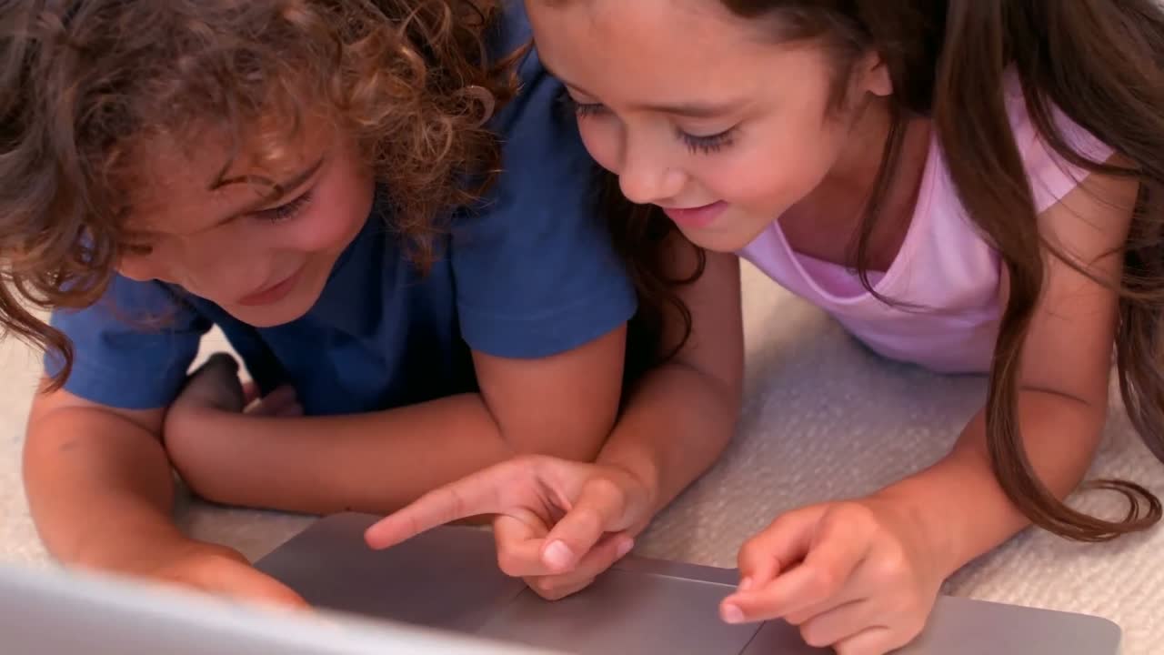 hermano y hermana usando computadora portátil