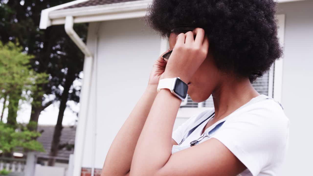 African American woman inspecting sunglasses switching to clear glasses for woodwork in front yard