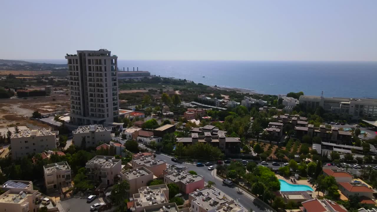 Aerial view of Durrës, Albania—coastal high-rise towers above mid-rise blocks and green urban sprawl. The scene captures architectural contrast, city planning, and seaside proximity