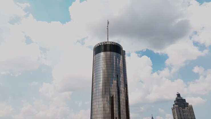Imagens aéreas ascendentes de uma torre redonda futurista com superfície espelhada