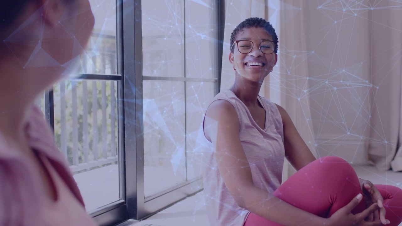 Woman with glasses starting chat, turning, settling, smiling by window, blue tech overlay appearing
