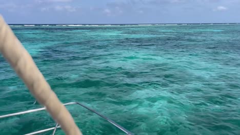 POV-from-a-sailboat-sailing-through-beautiful-clear-water-in-Caye-Caulker,-Belize