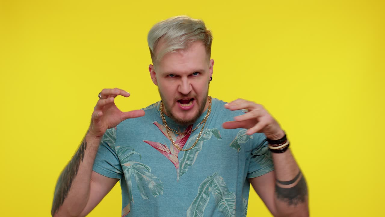 패션 티셔츠를 입은 미치광이 남자가 혀를 꺼내서 장난을 치고, 어리석은 표정을 짓고, 미치광입니다.