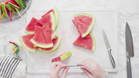 slicing red watermelon into small pieces