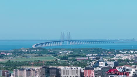 Telephoto-aerial-sideways-city-Malmo-and-stunning-bridge-Oresund-on-a-misty-day