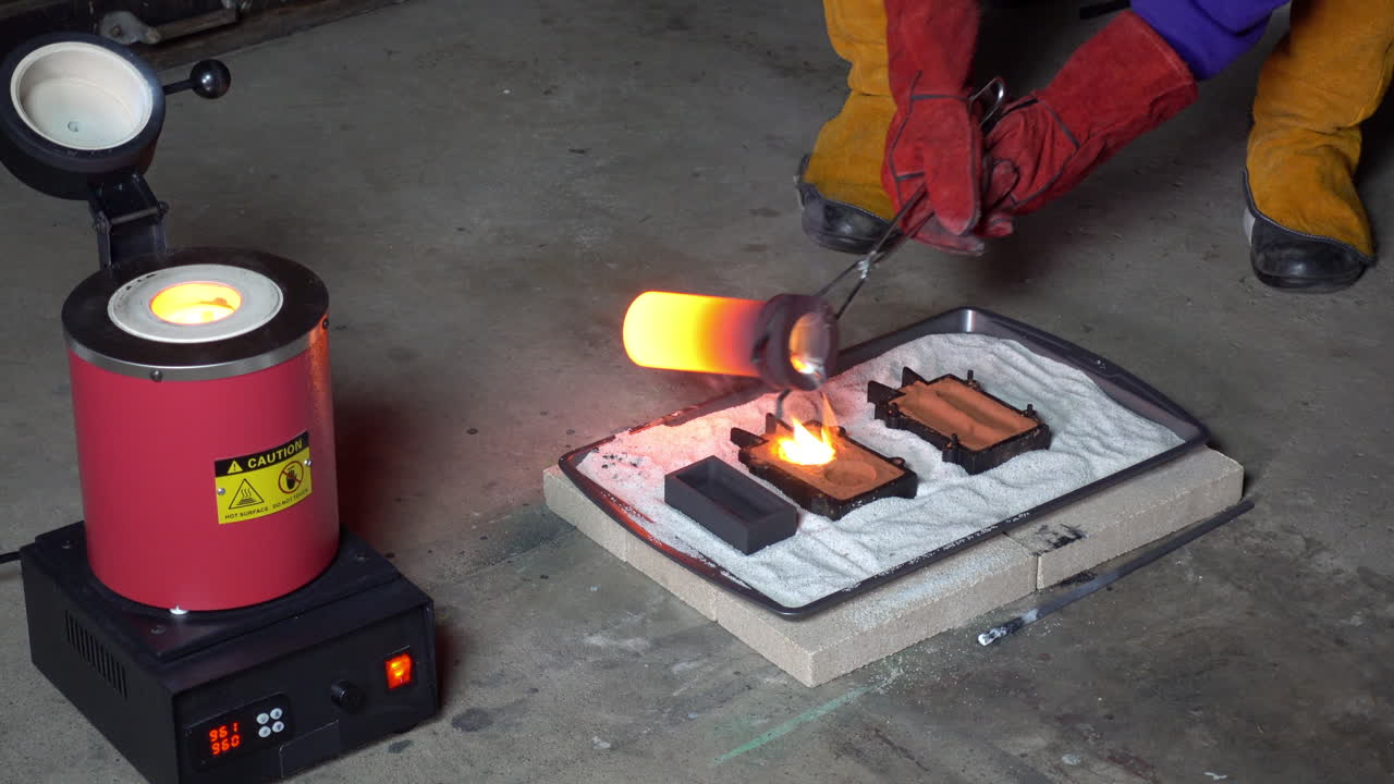 Crucible of molten metal is removed from furnace and poured into sand-casting molds