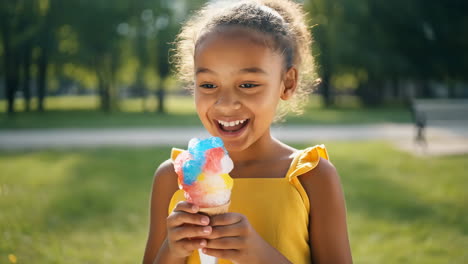 young girl eating a colorful snow cone outdoors