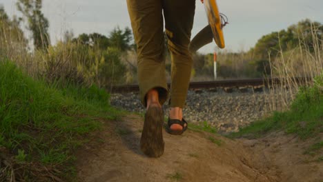 A-surfer-carries-his-board-as-he-hikes-down-to-a-remote-surf-spot-in-a-coastal-area-3