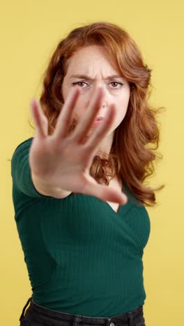 woman making a stop gesture with a serious expression