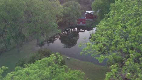 Aéreo---Reflejo-En-Un-Pequeño-Lago-En-Un-Rancho,-Nuevo-León,-México,-Reversa