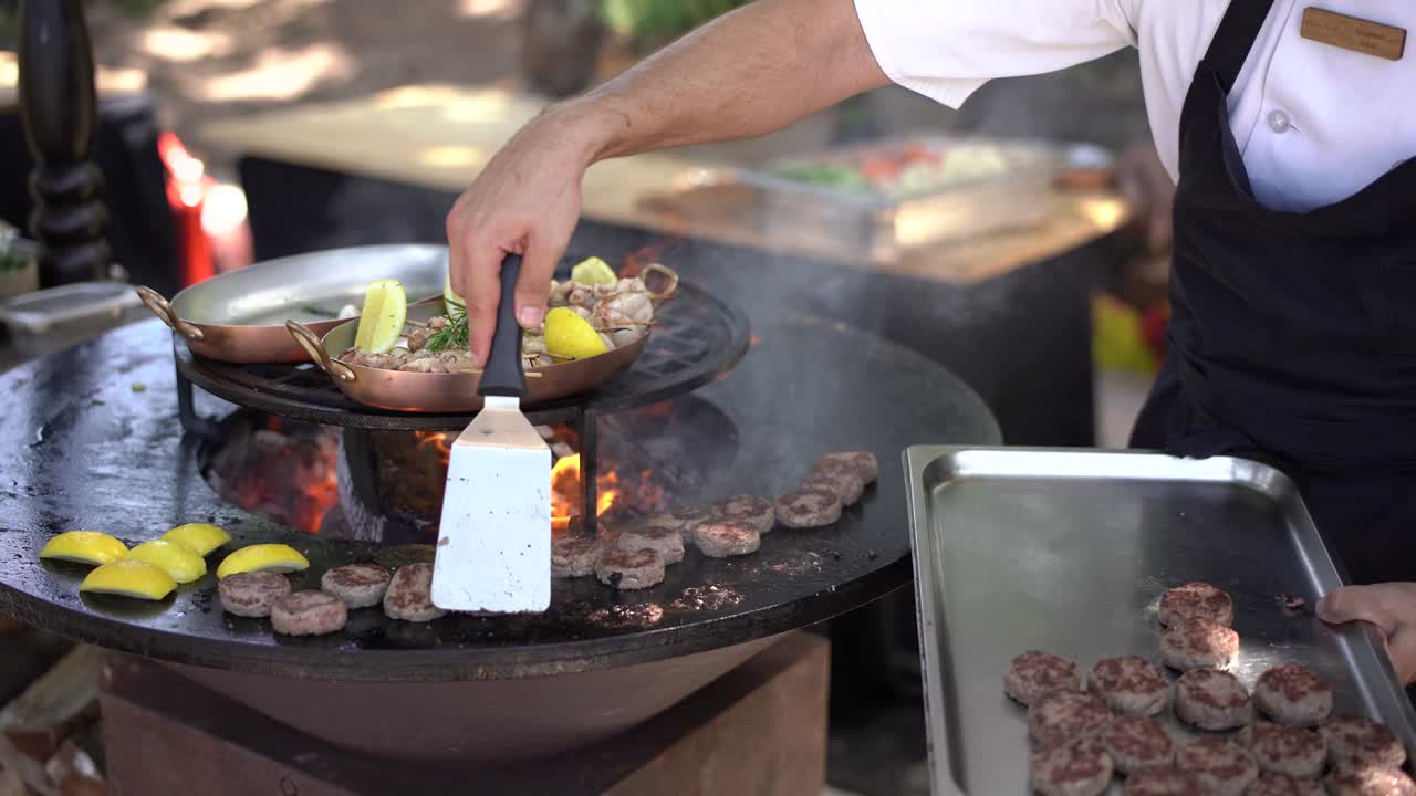 셰프는 미니 햄버거를 위해 육고기를 그릴에 니다.