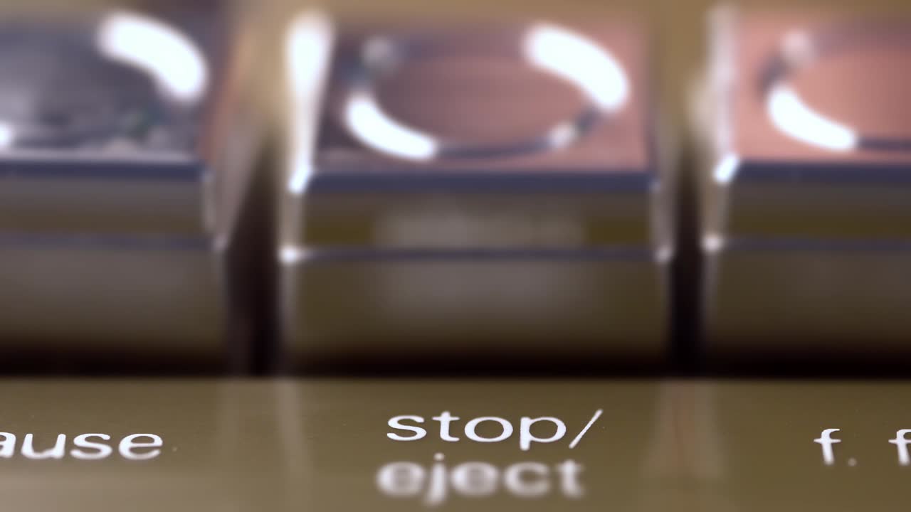 botón de parada de un grabador de cinta de época presionado por un macro de dedo