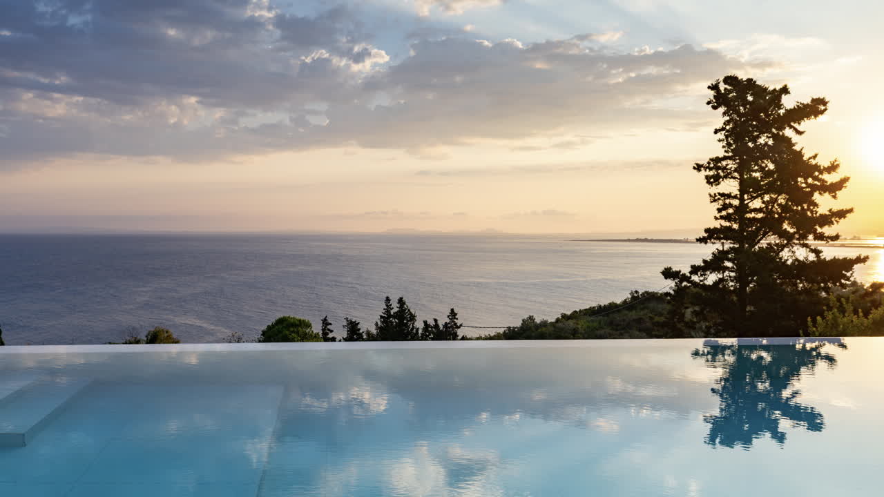 View of an infinity pool and sea and sky with horizon beyond at sunrise ...