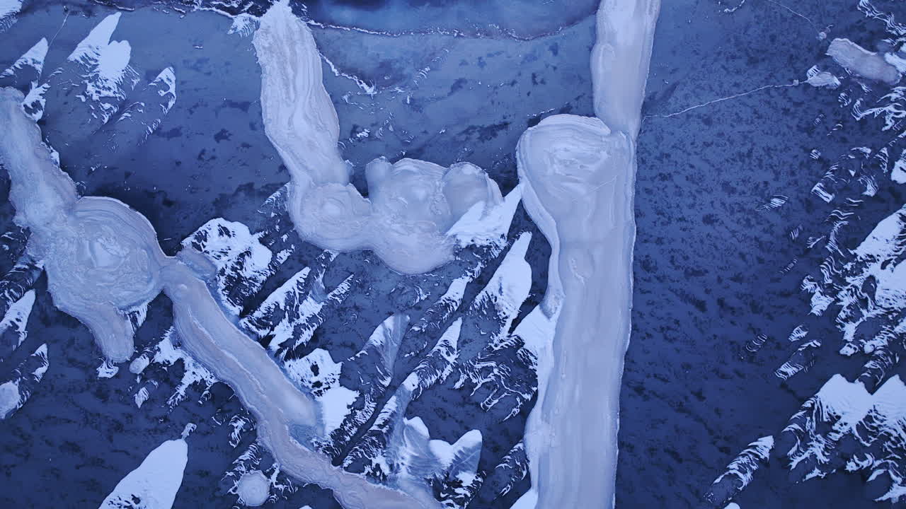 寒い冬の日に、ドローンが水面に浮かぶ巨大な氷の塊の上を滑空する息をのむような映像