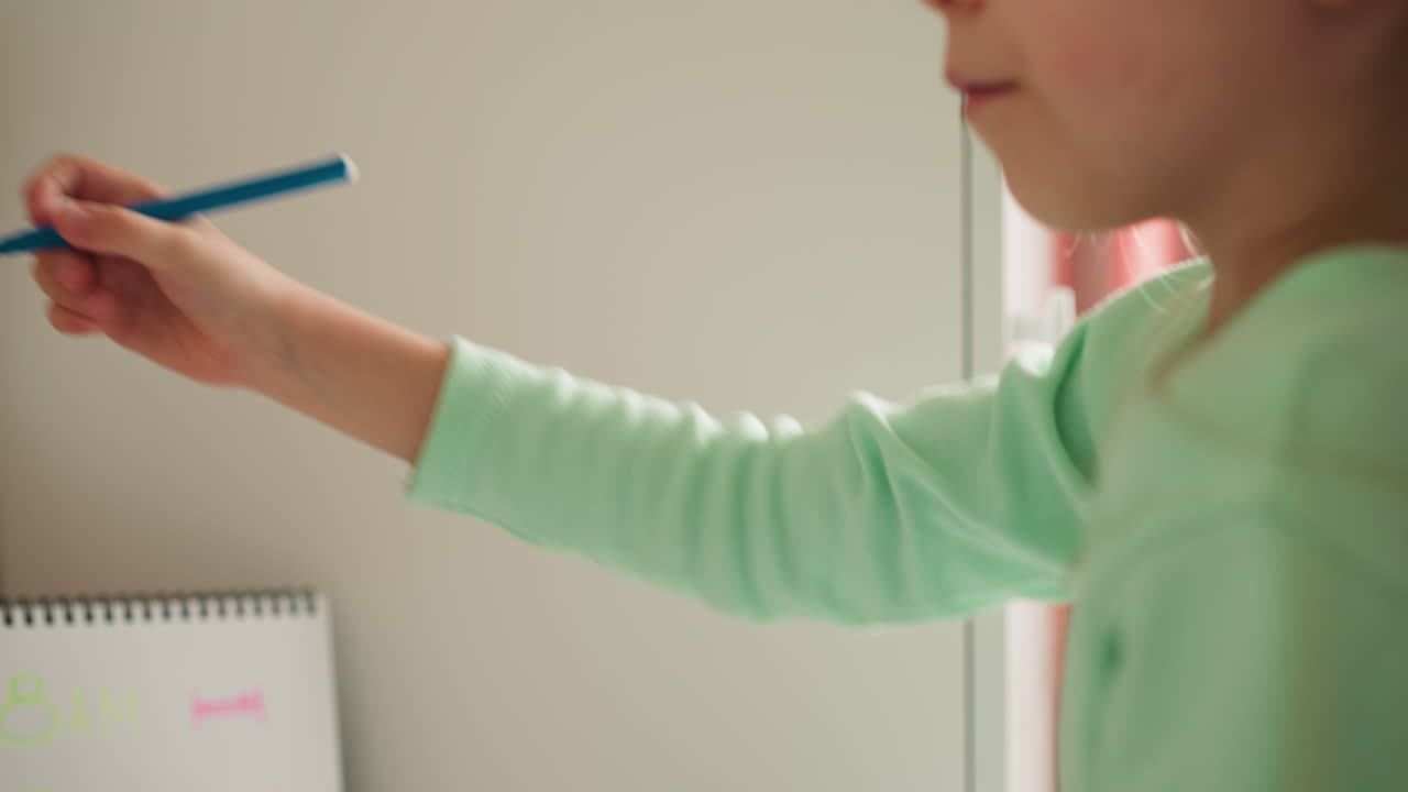 Girl takes off cap from felt-tip pen and stretches out hand